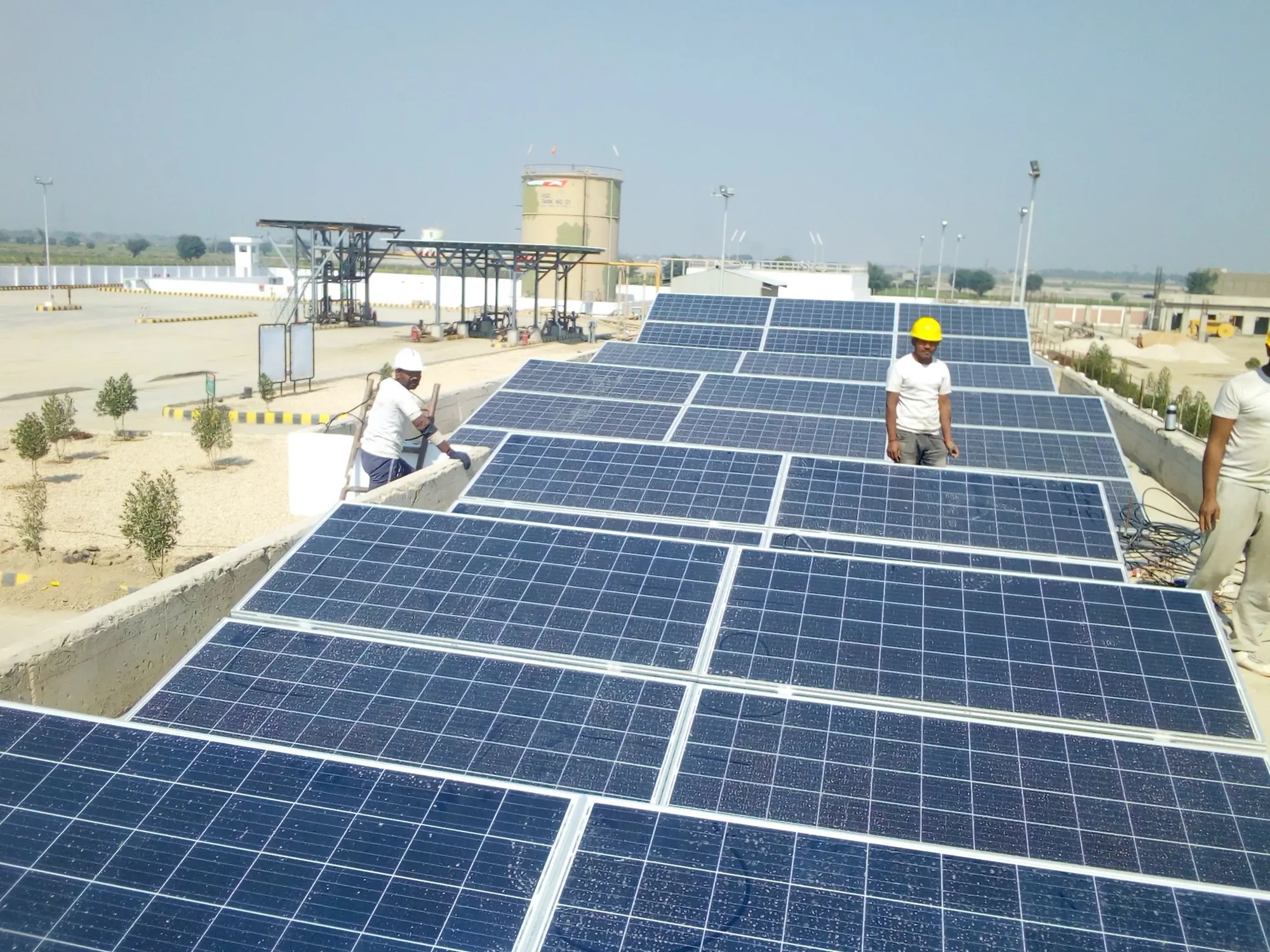Two workers walking between rows of panels on a large rooftop array